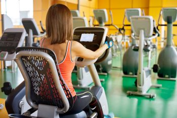 female working out on a recumbent cross trainer