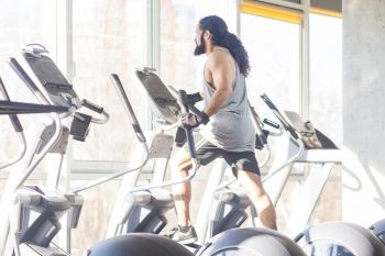 man working out on an elliptical trainer for heavy person