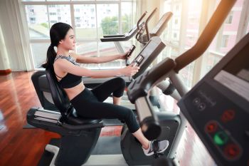 lady exercising on a recumbent stepper cross trainer